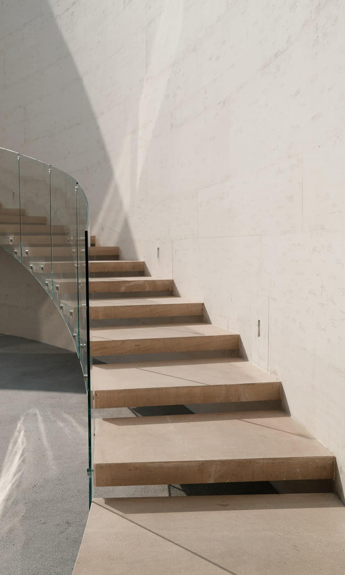 Escalera con baranda de vidrio curvo