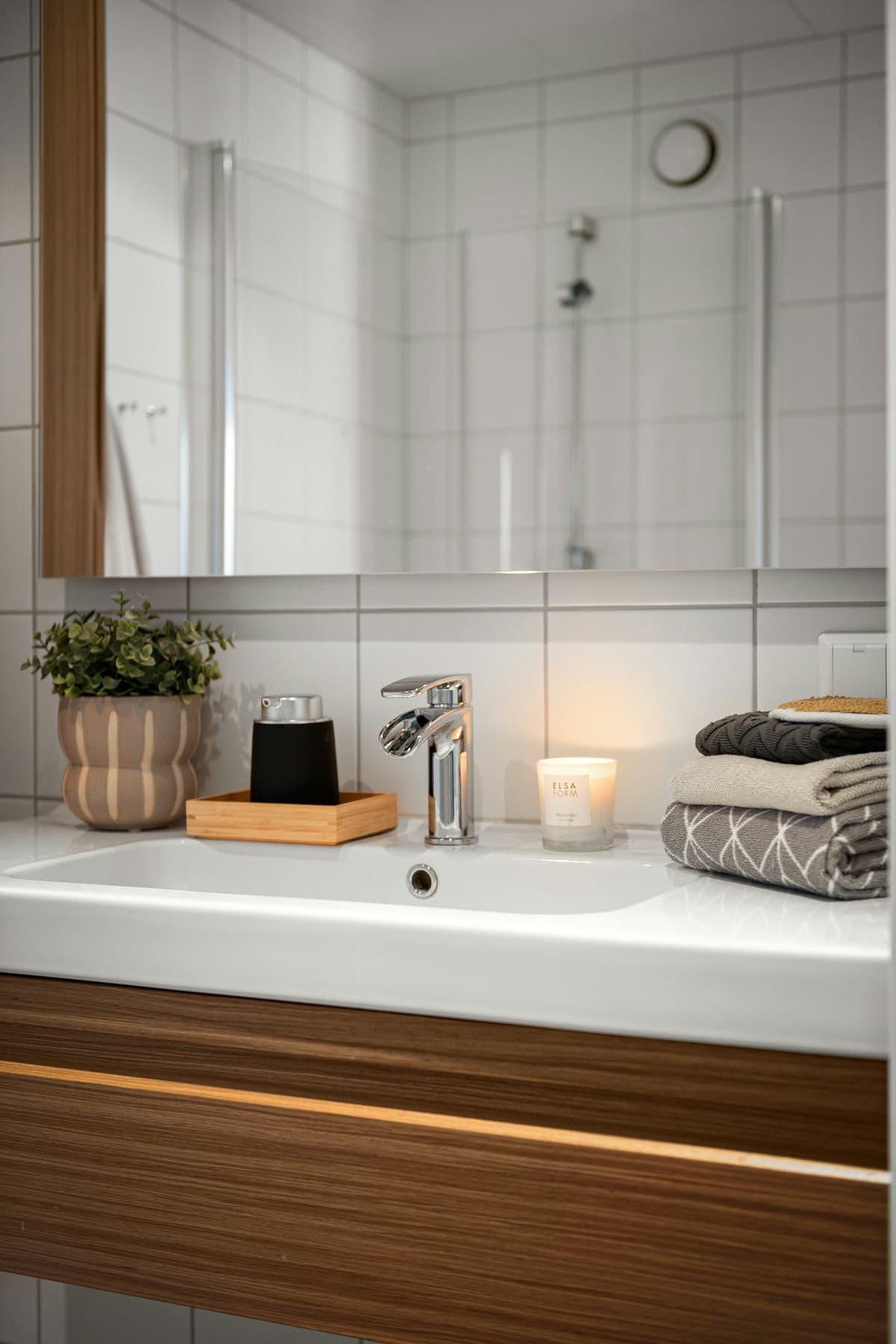 Baño con espejo sobre el lavamanos y mueble de madera