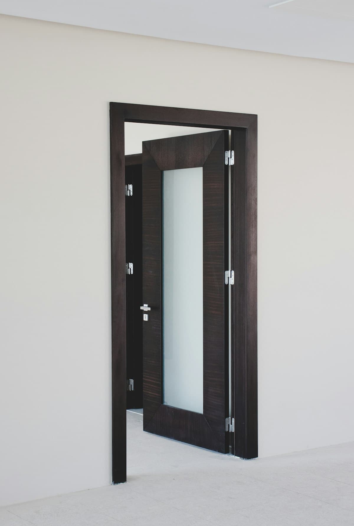 Puerta de madera oscura con panel de vidrio esmerilado