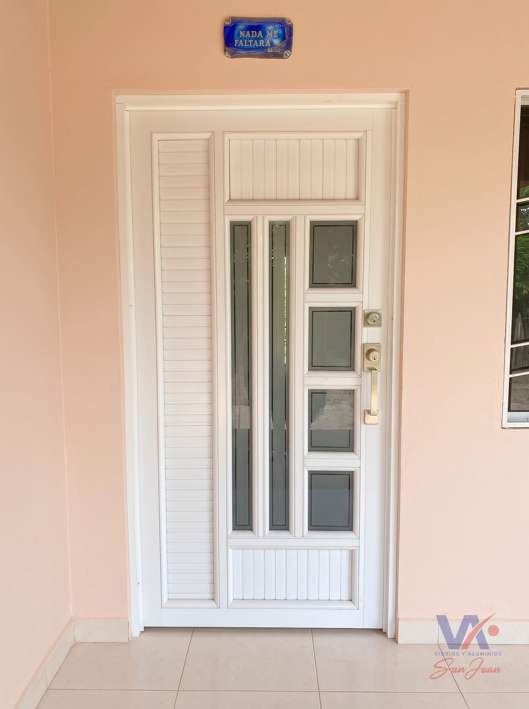 Puerta de aluminio color blanco con paneles acanalados y vidrios rectangulares