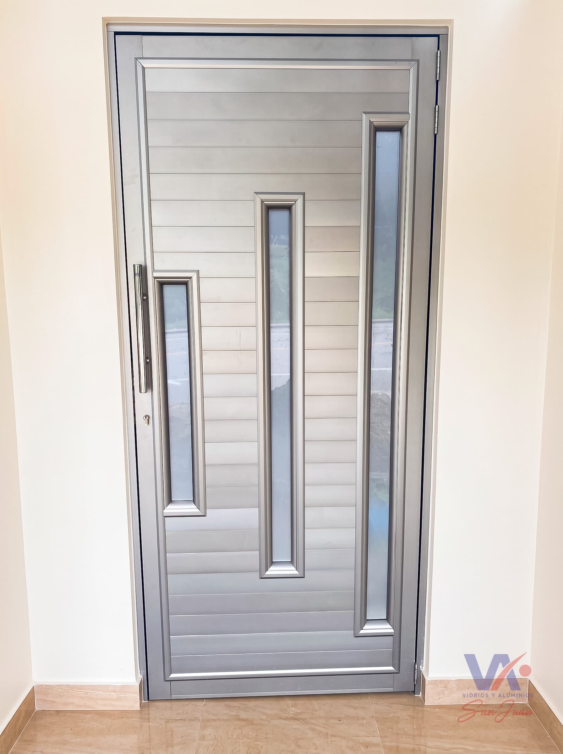 Puerta de aluminio color gris plata, instalada