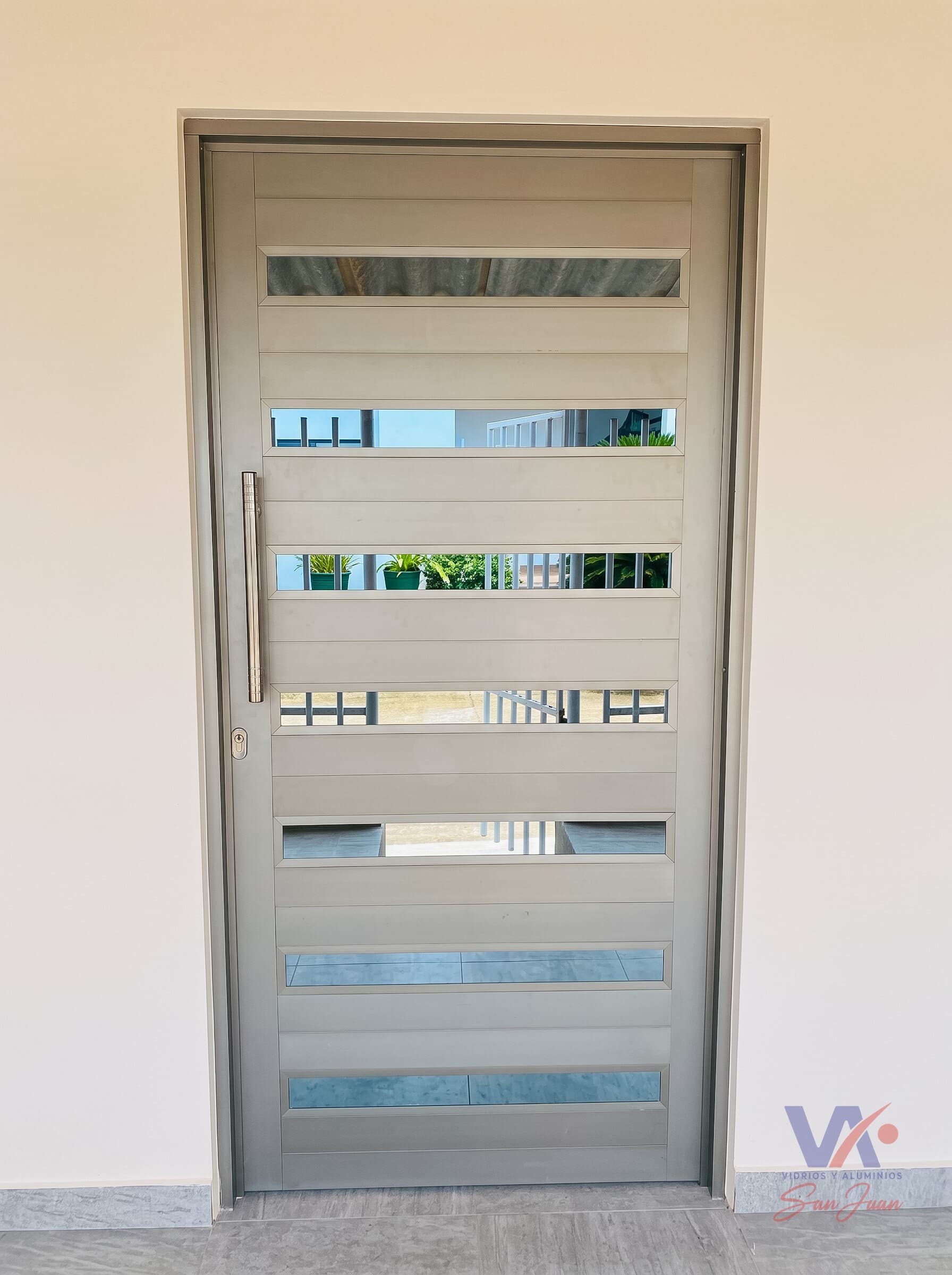 Puerta de aluminio color gris plata, instalada