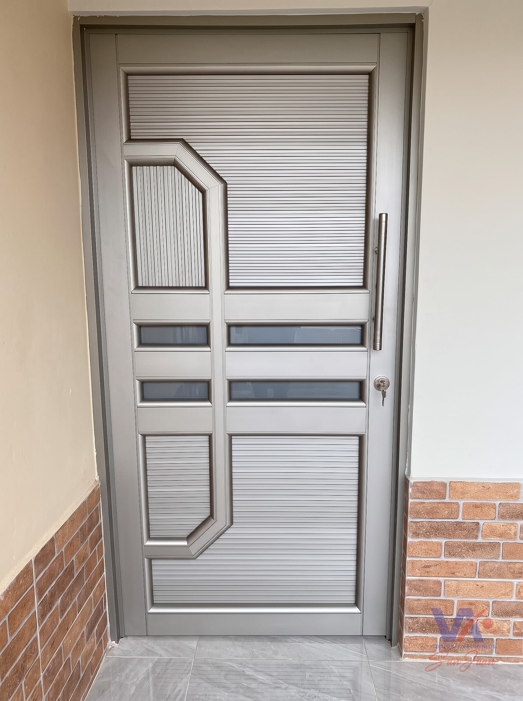 Puerta de aluminio color gris plata, instalada
