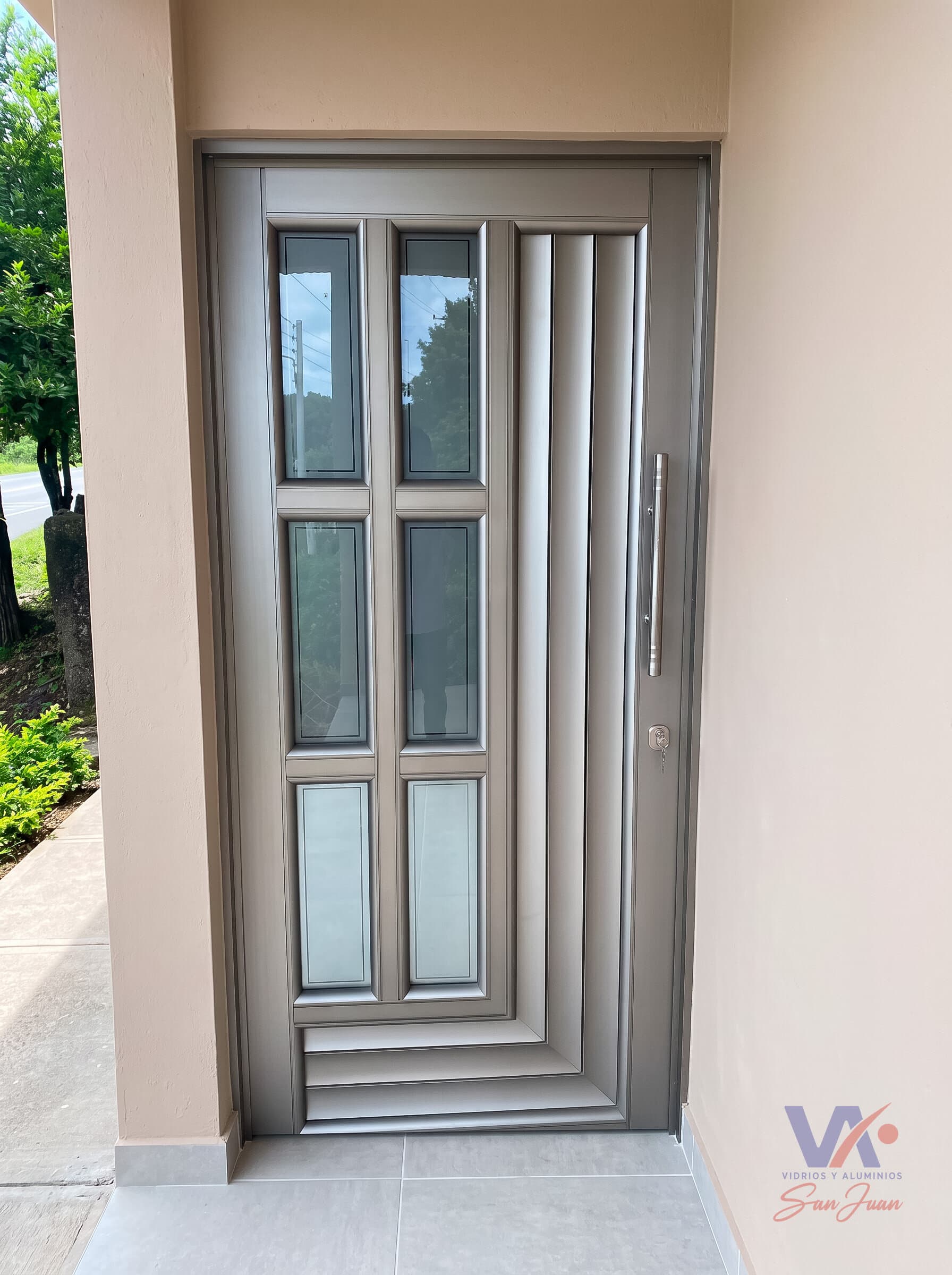 Puerta de aluminio color gris plata, instalada