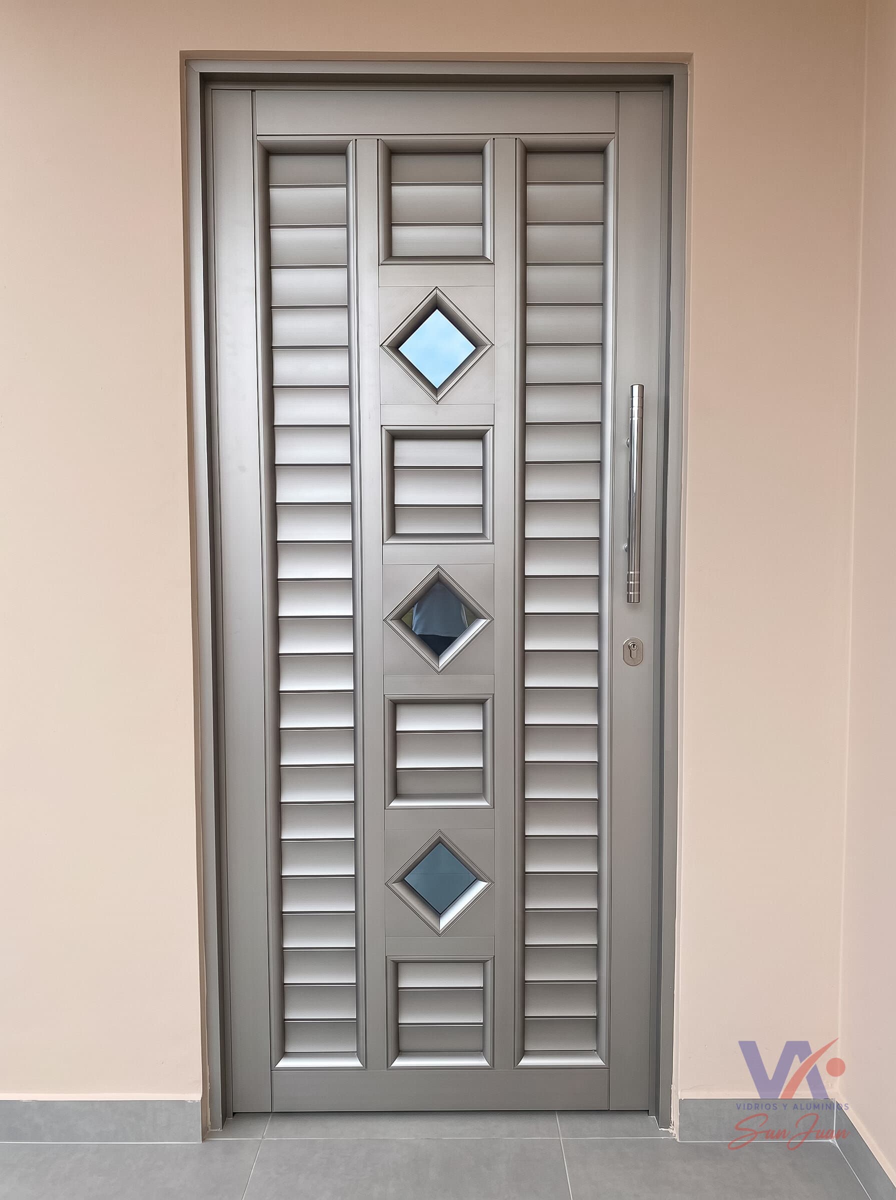 Puerta de aluminio color gris plata, instalada