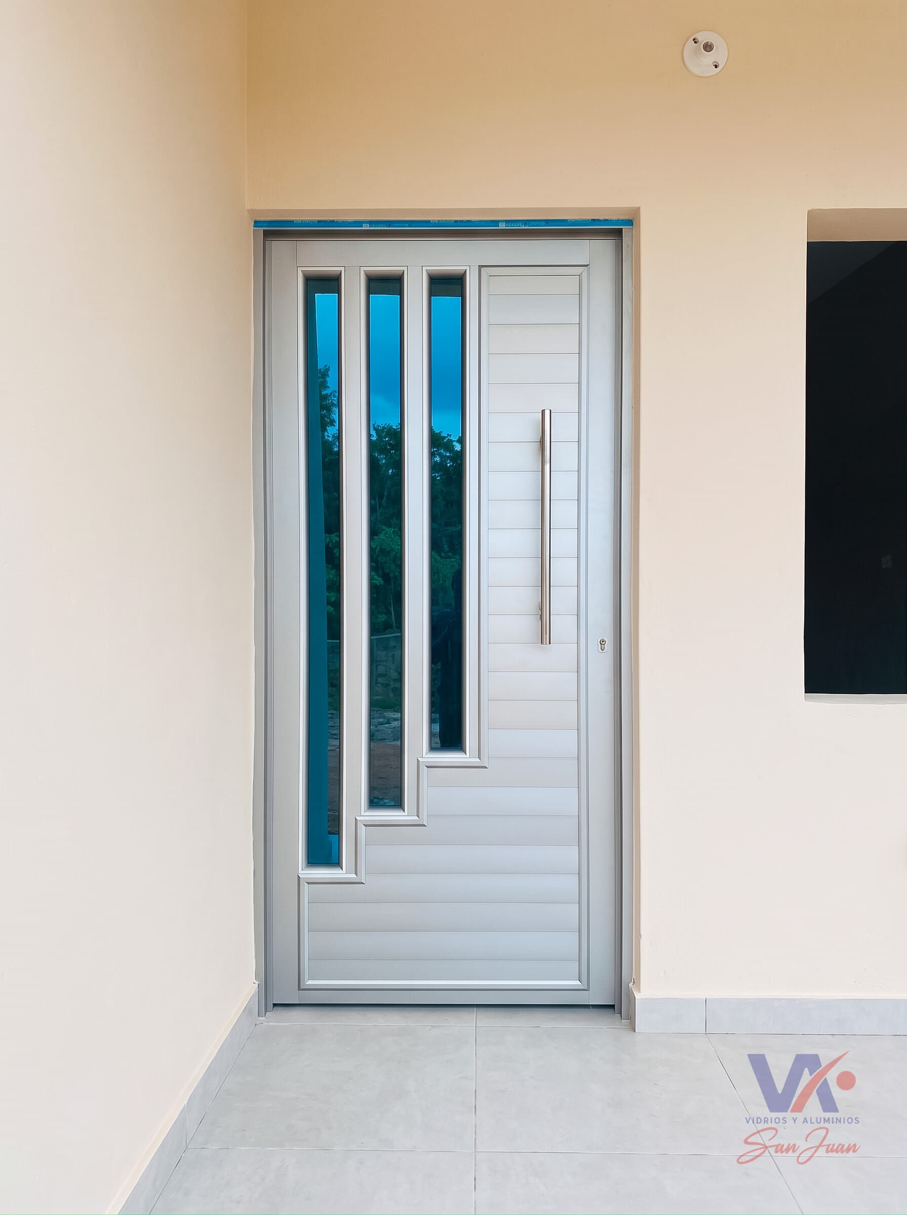 Puerta de aluminio color gris plata, instalada
