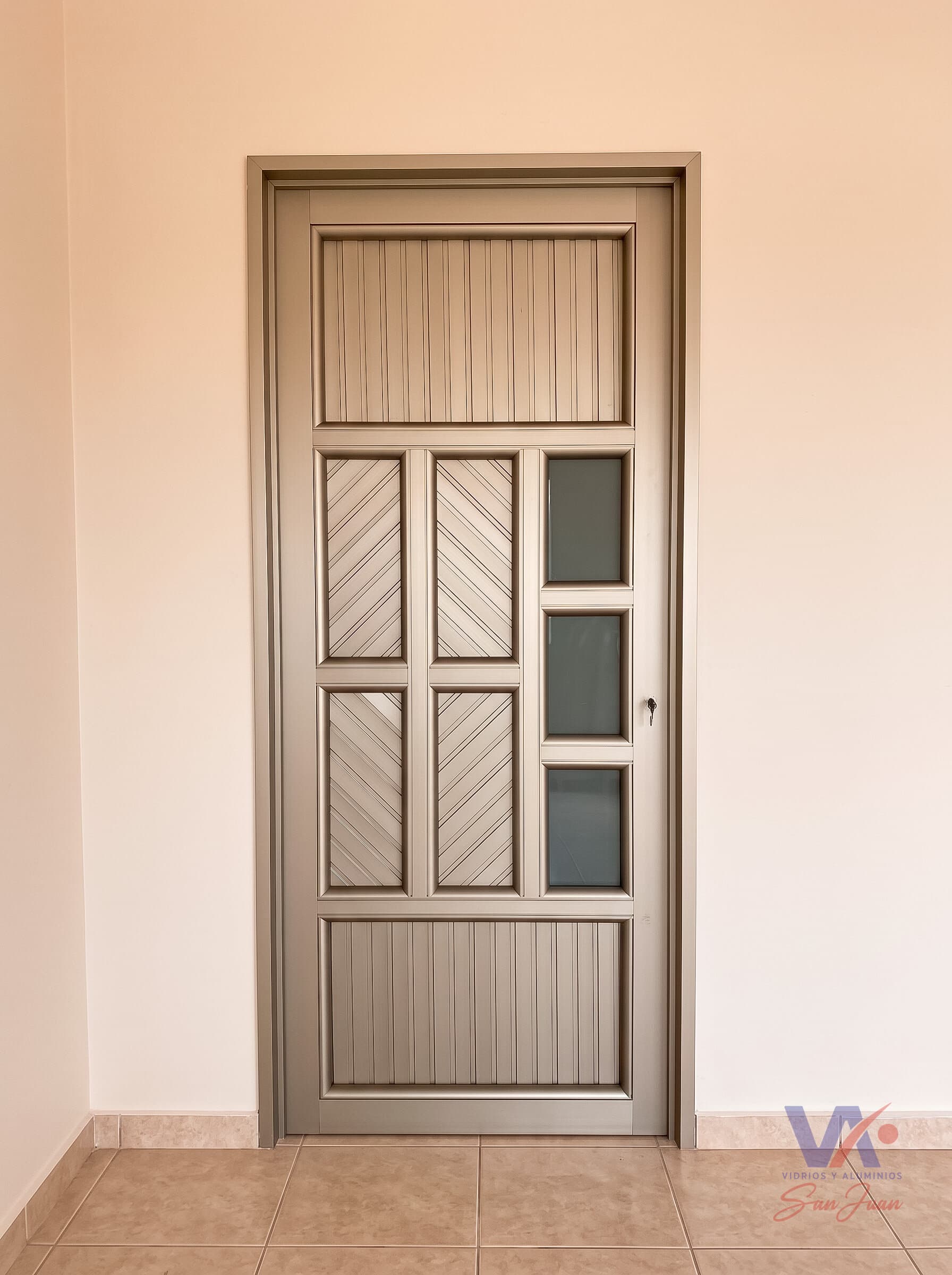 Puerta de aluminio color gris plata, instalada