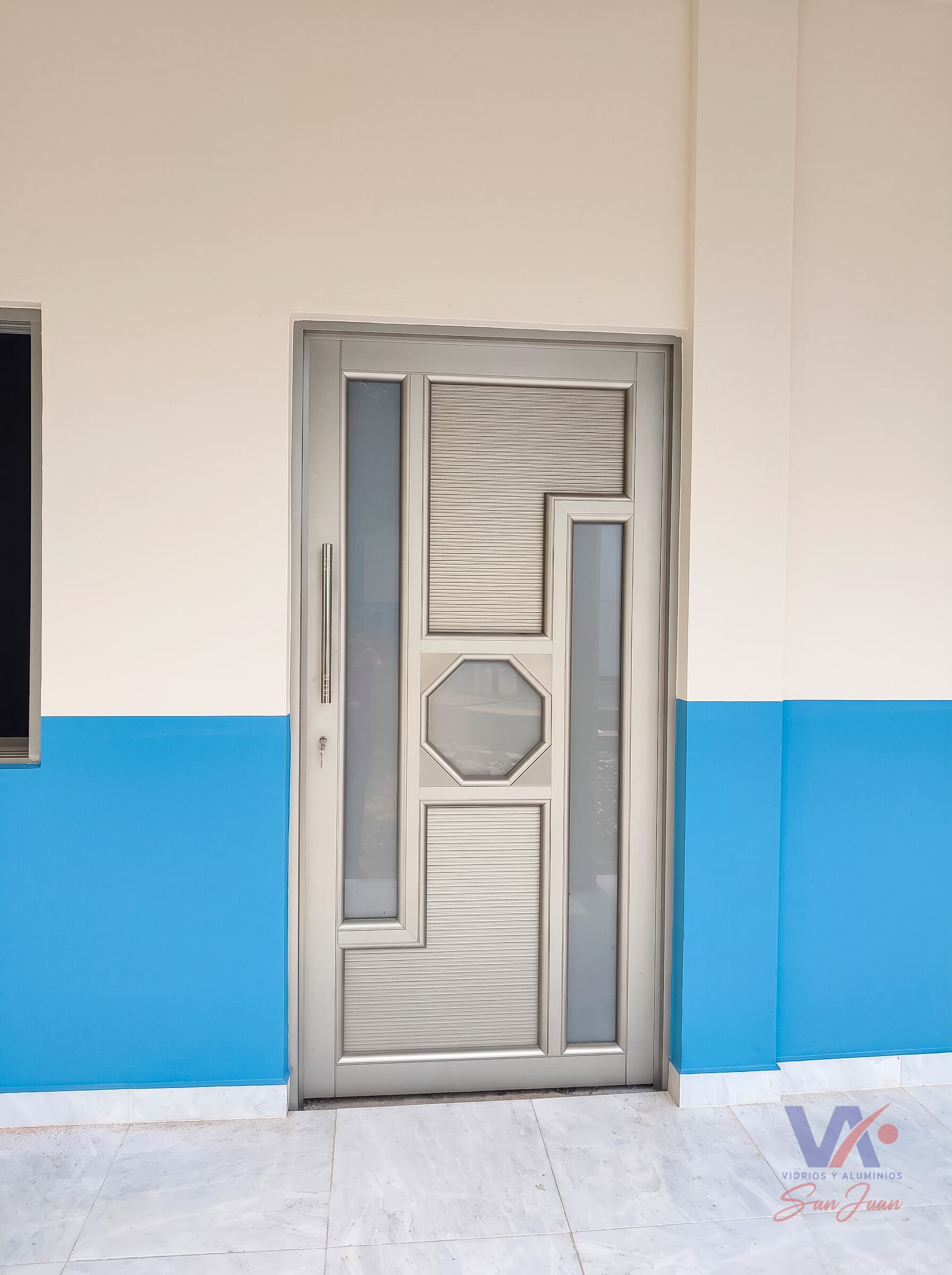 Puerta de aluminio color gris plata, instalada