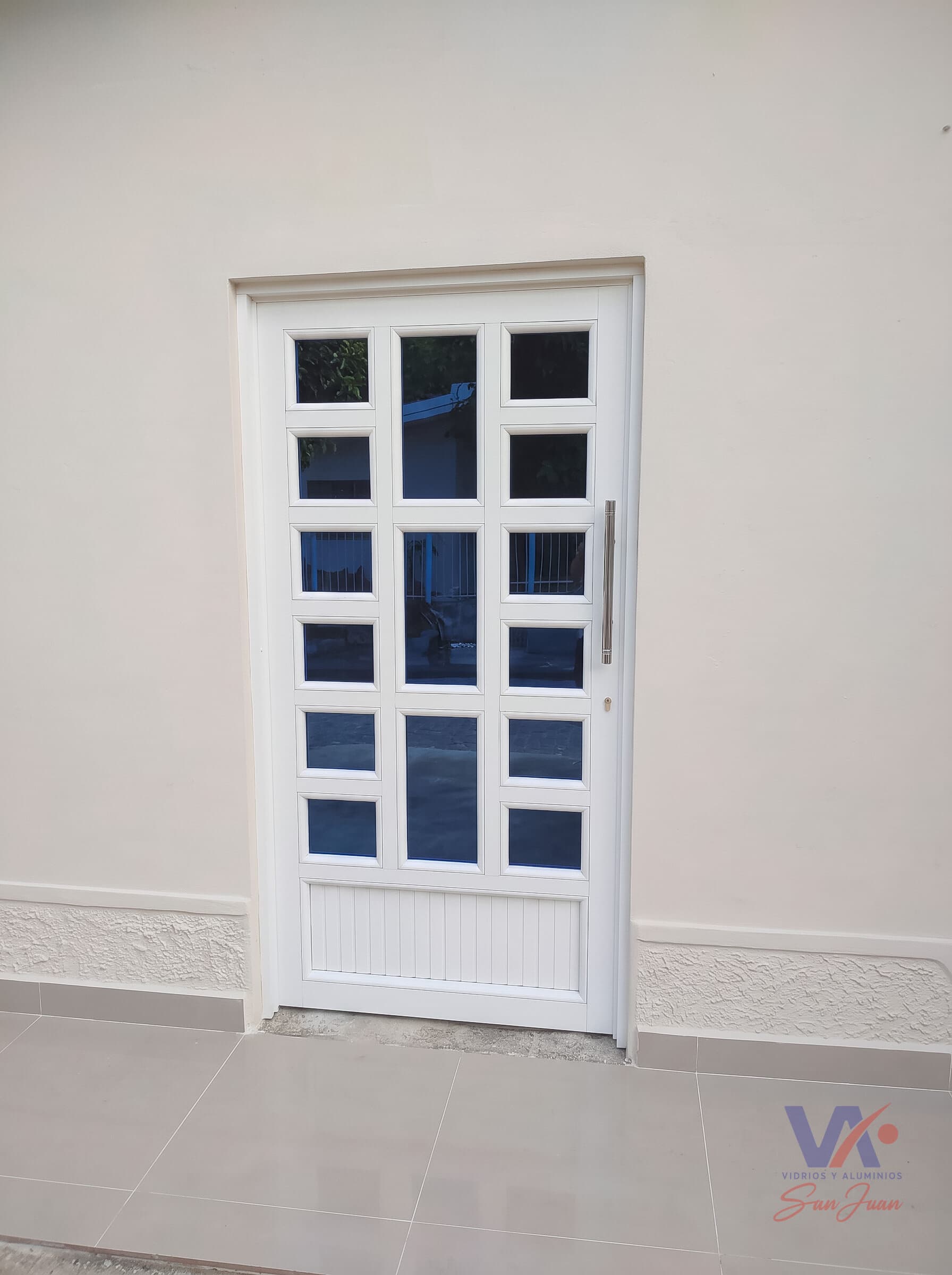 Puerta de aluminio color blanco, instalada